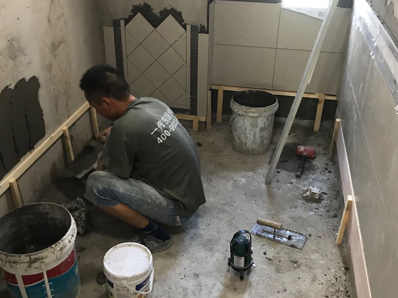 廁所瓷磚鋪貼裝修：首先應(yīng)除去基層表面的污垢，油漬，浮灰;除去基層上所有涂料層，膩?zhàn)訉?如果基層未能達(dá)到平整度要求，需對基層進(jìn)行預(yù)先的找平處理；鋪貼瓷磚前需事先找好垂直線，以此為基準(zhǔn)鋪貼的瓷磚高低均勻、垂直美觀;將調(diào)制好的漿料均勻地抹在瓷磚背面，要求漿料飽滿；將瓷磚平整地鋪貼在基層上，使用橡膠錘將瓷磚拍實(shí)鋪平。