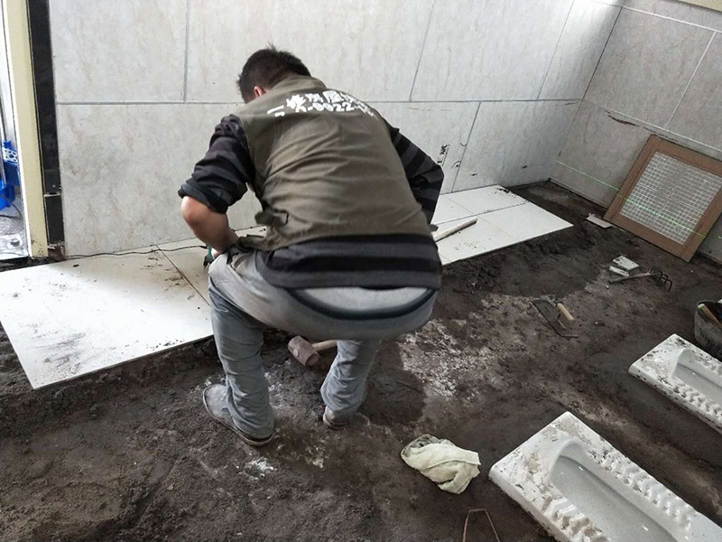 公廁貼磚維修：基層處理：應(yīng)全部清理墻面上的各類污物，打掃干凈現(xiàn)場，特別是腳落里。 批墻、墻面找平：用泥刀先批墻，后用水泥漿找平。這個工序很重要，確保底子平，防止貼后空鼓。 刷防水涂料：墻面要刷防水涂料，防止貼后浸水，一般高度不低于1.8米，刷的時候會稍高一些。 找水平基準(zhǔn)線：根據(jù)設(shè)計鋪貼圖樣的要求，確定排磚方案，用墨斗彈線，以減少施工損耗。 粘結(jié)劑上墻：把剛剛攪拌好的粘結(jié)劑漿料均勻的刮到墻上。 瓷磚上墻將經(jīng)過預(yù)先清潔的瓷磚平整地鋪貼在粘結(jié)劑漿料基層上，使用橡膠錘將瓷磚拍實鋪平。施工過程中，可小幅度轉(zhuǎn)動瓷磚，使?jié){料與瓷磚背面充分接觸。專家建議在鋪貼時，隨機取下已鋪貼于基層上的瓷磚作檢查。確保漿料與瓷磚背面的充分接觸。 留縫大小調(diào)整根據(jù)瓷磚的尺寸，在磚與磚之間預(yù)留相應(yīng)尺寸的縫隙留待嵌縫。可用牙簽等先固定，粘結(jié)劑具有一定的可調(diào)整性，可對留縫的大小進行調(diào)整。