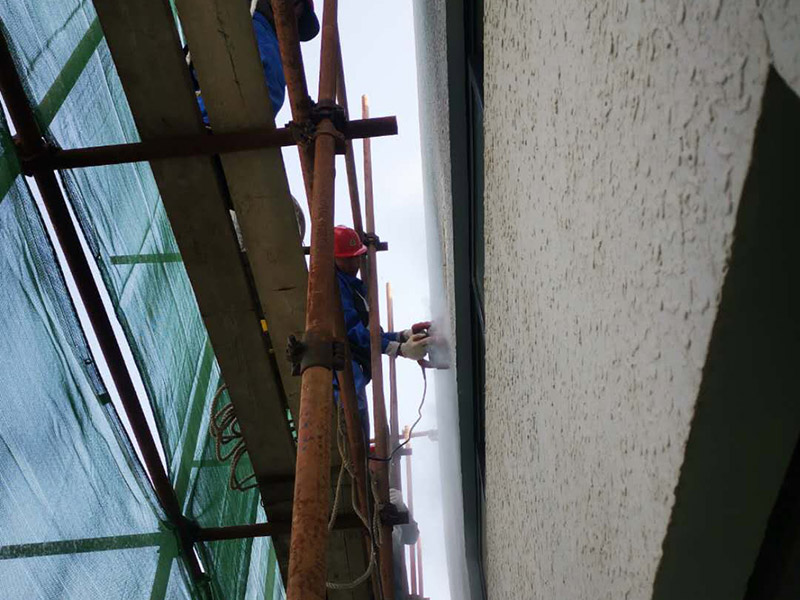 高空外墻防水：首先清理基層，新舊面層必須清理干凈，不得有雜物和灰塵，以免影響粘結(jié)強度，涂刷防水涂料時基層應(yīng)干燥。接下來，清理死角，也就是所謂的陰陽角、施工縫、伸縮縫等比較重要的部位進行處理，尤其注意的是泄水孔要加強處理，需要涂刷2-3遍防水底層涂料。備好防水卷材、防水涂料、基層涂料和粘接卷材的涂料必須要分清，為提高防水卷材與基層粘結(jié)性，可用底層涂料反復(fù)涂刷，涂刷均勻，覆蓋完全，充分滲入混凝土基層，以提高粘結(jié)強度和抗剪切強度。涂刷第二次涂料之前必須要等第一次涂料完全凝固后方可再次涂刷，底層涂料第一次涂刷完畢后約4-8小時左右，方可再次涂刷第二次和第三次底層涂料。