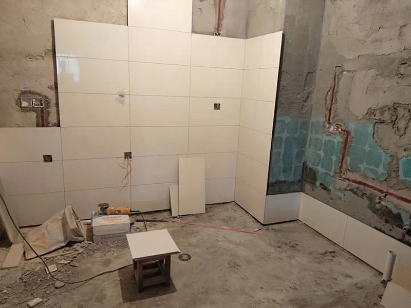 浴室墻面貼瓷磚：貼瓷磚之前先要用水浸泡瓷磚2小時左右。泡水的目的是為了讓瓷磚能事先吸飽水分，避免鋪貼之后吸走粘接材料中的水分，從而影響粘接的強度，浸水后記得用棉布擦去表面的水分晾干后才能進(jìn)行鋪貼。鋪貼開始前還應(yīng)吊垂線，來確定瓷磚的尺寸線，然后開始貼瓷磚，一般都是從門窗先開始，而且按由下而上，自左至右的順序進(jìn)行。鋪貼的方法是先用水潤濕找平層，然后用鏟子將事先拌好的粘接材料抹在瓷磚背面，再將瓷磚貼在墻上即可，依次鋪貼平整就可以了。