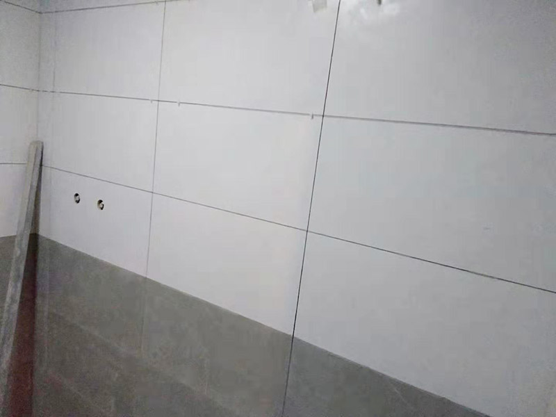 浴室墻面貼瓷磚：貼瓷磚之前先要用水浸泡瓷磚2小時左右。泡水的目的是為了讓瓷磚能事先吸飽水分，避免鋪貼之后吸走粘接材料中的水分，從而影響粘接的強度，浸水后記得用棉布擦去表面的水分晾干后才能進(jìn)行鋪貼。鋪貼開始前還應(yīng)吊垂線，來確定瓷磚的尺寸線，然后開始貼瓷磚，一般都是從門窗先開始，而且按由下而上，自左至右的順序進(jìn)行。鋪貼的方法是先用水潤濕找平層，然后用鏟子將事先拌好的粘接材料抹在瓷磚背面，再將瓷磚貼在墻上即可，依次鋪貼平整就可以了。