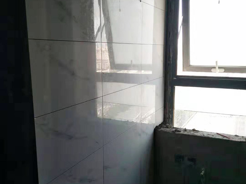墻面貼磚施工：工藝流程  清理墻面bai——澆水濕潤墻——面找du規矩——zhi底層抹灰——排磚、分格dao、彈線——鑲貼面磚——清掃面層——勾縫——清洗墻面 清理墻、柱面，應將浮灰及殘余砂漿沖洗干凈，再充分澆水濕潤。  柱與墻面的陰陽角轉角處，均需拉垂直線并進行兜方。陽角要雙面拉垂直線，門窗上下口拉水平通線。   根據掛線情況和面磚規格尺寸排列要求，打底子灰，底子灰分兩次施工。水泥砂漿采用砂漿機攪拌，配比必須準確。  鑲貼面磚前一天，將面磚放入水桶中浸泡，使用前1－2小時取出，晾去表面水，抹凈表面浮灰待用。   面磚鑲貼順序為自上而下，按建筑分層為界，完成一層再做一層。粘貼第一層面磚時需用直尺在面磚底部托平，保持頭角齊直，條縫平直，貼完第一層后用直尺檢查一遍平整度。貼第二層面磚時應將第一層面磚上的灰漿刮平，放下一層面磚，對好縱橫縫，對齊垂直度后鋪貼，操作方法如上。   勾縫需待一個層次的面磚鑲貼完畢后進行。應使用特制熘子進行勾縫，以保證磚縫深淺一致、表面平整。磚縫必須抹壓密實，以防縫隙內浸水。   鑲貼面磚完工后，隨即清理面磚表面，做好成品保護。