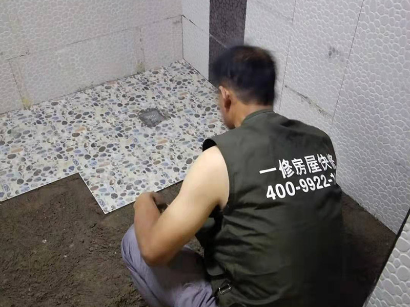 衛生間地面花磚鋪貼:找平，就是在鋪仿古磚前，對鋪貼物表面進行處理，如地面、內墻面、外墻面等，消除表面附著的污物，并灑水進行滋潤，然后用水泥沙混合找平，通常使用灰鏟在表面不停的涂抹使水泥地面保持大致水平，一定要等到水泥沙混合物完全干爽后再行鋪貼。用一段較長的細線，根據確定的鋪貼方式，在線上涂上顏色或白灰，然后在找平的地面上畫出仿古磚的位置及磚縫的參考線。 將亞光磚置入清水中浸泡，使瓷磚充分吸收水分，以不冒出氣泡為準，防止干燥瓷磚在裝修完成后再次吸水而導致磚體變形。取出浸泡好的瓷磚，抹干水漬，在找平層上噴灑足夠的水，然后在磚背面均勻抹上水泥沙漿，沙漿厚度5~6cm為宜，鋪貼大規格亞光磚時適當加厚；隨即將磚貼上，用木錘輕輕拍牢平整，避免空鼓，并隨時用直尺找平。