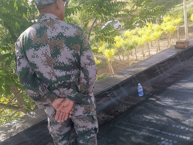 屋頂防水卷材鋪貼:清除基層表面雜物、油污、砂子，凸出表面的石子、砂漿疙瘩等應清理干凈，清掃工作必須在施工中隨時進行，并修補平整表面。尤其鏟除排水口、煙囪、管壁上的水泥砂漿等附著物；根據施工現場狀況，進行合理定位，確定卷材鋪貼方向，在基層上彈好卷材控制線，依循流水方向從低往高進行卷材試鋪。卷材試鋪后，先將要鋪貼的卷材剪好，反鋪于基面上(即是底部隔離紙朝上)，撕剝去卷材隔離紙。撕剝時，已剝開的隔離紙宜與粘結面保持45～60度的銳角，防止拉斷隔離紙，盡量保持在自然松弛狀態，但不要有皺折。