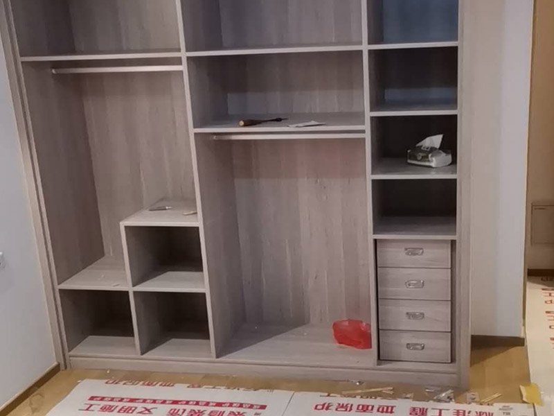 家具柜體安裝：用墊布點好地板，先從靠墻的一端寬du側板開始組裝，將寬側板平放于地面上(離后墻面保持700mm間隔)。首先將填好的三合一膠塞的板件，平放在墊布上，檢查孔距與圖紙相符，并裝上三合一單連桿。然后將固層釘上木塞，固定于寬側板上面，頂板大柄孔朝上，其余固層都朝下，腳線大柄孔朝內(中間固層與L架高度一致，即底板到固層內空為960mm，現場打層板孔)。放上側板，釘上木塞，木塞要求連通兩邊的固層。在第二個柜固層上面裝好雙連桿，留意雙連桿上面大柄只能鎖住一半，即90°。當兩件固層與側板固定后再同時擰緊大柄。 釘背板：把裝好的整體柜側放在點好墊布的地板上面，墊平側板成統(tǒng)一平面。用拉尺量好柜子的對角尺寸，調至相等，從寬測板處開始裝第一塊背板，留意假如中間有固層釘釘子時，先用鉛筆畫好固層的中央線，再釘釘子。