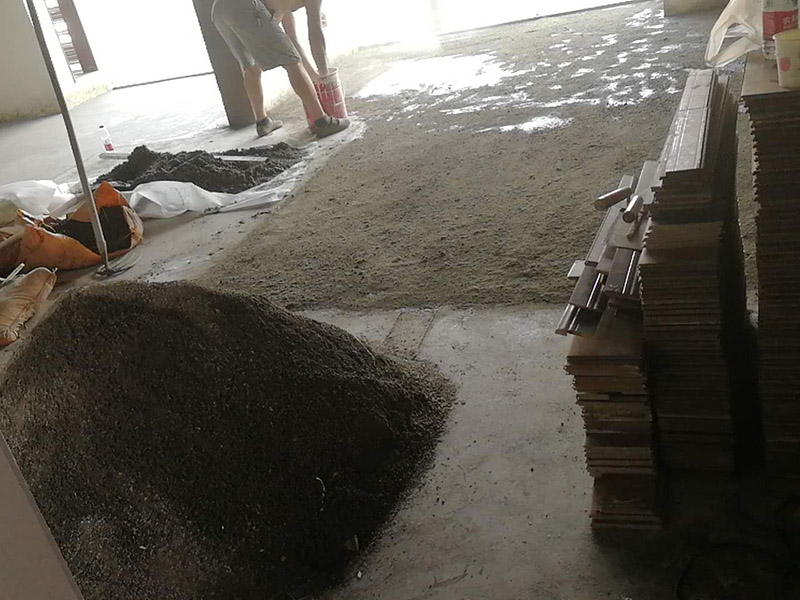 老房子地面找平：基層處理→找標高、彈線→灑水濕潤→抹灰餅和標筋→攪拌砂漿→刷水泥漿結合層→鋪水泥砂漿面層→木抹子搓平→鐵抹子壓第一遍→第二遍壓光→第三遍壓光→養護 將基層上的灰塵掃掉，用鋼絲刷和鏨子刷凈、剔掉灰漿皮和灰渣層，用10%的火堿水溶液刷掉基層上的油污，并用清水及時將堿液沖凈。 根據墻上的+1000mm水平線，往下量測出面層標高，并彈在墻上。 根據房間內四周墻上彈的面層標高水平線，確定面層抹灰厚度（不應小于20mm）,然后拉水平線開始抹灰餅（5cm*5cm），橫豎間距為1.5—2.0米，灰餅上平面即為地面面層標高。如果房間比較大，還須抹標筋。鋪抹灰餅和標筋的砂漿材料配合比均與抹地面的砂漿相同。 攪拌砂漿，用攪拌機進行攪拌，顏色必須一致。鋪設水泥砂漿前，涂刷水泥漿一層（隨刷隨鋪面層砂漿）。 在涂刷完水泥砂漿后，鋪水泥砂漿，并在灰餅之間將砂漿鋪均勻。 木抹子刮平后，迅速用鐵抹子壓第一遍，直到出漿為止。面層砂漿初凝后，用鐵抹子壓第二遍，表面壓平壓光。在水泥砂漿終凝前進行第三遍壓光，必須在終凝前完成。 并隨時用2米靠尺檢查其平整度。 完工后24小時（地面壓光），鋪鋸末或其他材料覆蓋灑水養護，保持濕潤，養護時間不少于7天，抗壓強度達5Mpa時才能上人。