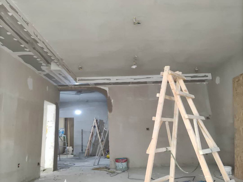 客廳吊頂造型施工：在客廳四周做吊頂，中間不做吊頂。這種吊頂可用木材夾板成型，設計成各種形狀，在配以射燈或筒燈，在不吊頂的中間不分配上新穎的吸頂燈。這樣會在視覺上增加視覺的層高，教適合于大空間的客廳。將客廳四周的吊頂做厚，而中間部分作薄，從而形成兩個明顯的層次。 確定吊頂區域,在相鄰墻面彈出水平線，畫龍骨固定線，頂面打空,栽內漲絲,旋緊鍍鋅吊掛傳絲，架設輕鋼龍骨，用防銹自功釘固定石膏板并留出筒燈安裝點位，在石膏板銜接處預留8-10mm空隙,充填石膏外貼牛皮紙，用防銹漆將所有釘眼涂。
