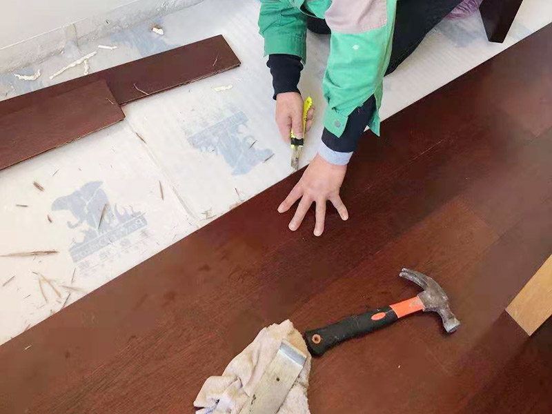 木地板鋪設施工：地面已經清理干凈、平整之后，先要鋪設一層防潮地墊(不一定非要鋪在木質地面的木頭下面)。這一層至少要20-30厘米(大約8英寸)在離墻大約預留1-3英寸的空隙。現在可以安裝已經選好花色的地板了。需要注意的是所鋪設的防潮地墊只需要鋪設大致5—10排的地板。 要確保在地板與墻壁之間留有大約10mm(3/8英寸)的空隙。為了防止地板的第一行的地板滑動，必須用間隔的裝置或者楔子固定。第一行余下的板通常用在第二行的開頭。要確保第二行板的接口與第一行板的接口錯開的長度至少30厘米(1英尺)。