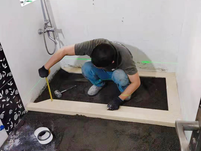 衛生間貼磚施工：應全部清理墻面上的各類污物，打掃干凈現場，特別是腳落里。用泥刀先批墻，后用水泥漿找平。這個工序很重要，確保底子平，防止貼后空鼓。墻面要刷防水涂料，防止貼后浸水，一般高度不低于1.8米，刷的時候會稍高一些。根據設計鋪貼圖樣的要求，確定排磚方案，用墨斗彈線，以減少施工損耗。用鋸齒鏝刀拉槽這點是目前新工藝區別老工藝的一點，使用將粘結劑漿料抹在待鋪貼基層表面，經由鋸齒鏝刀梳理后的條狀漿料飽滿并連續不間斷。瓷磚上墻將經過預先清潔的瓷磚平整地鋪貼在粘結劑漿料基層上，使用橡膠錘將瓷磚拍實鋪平。施工過程中，可小幅度轉動瓷磚，使漿料與瓷磚背面充分接觸。專家建議在鋪貼時，隨機取下已鋪貼于基層上的瓷磚作檢查。確保漿料與瓷磚背面的充分接觸。