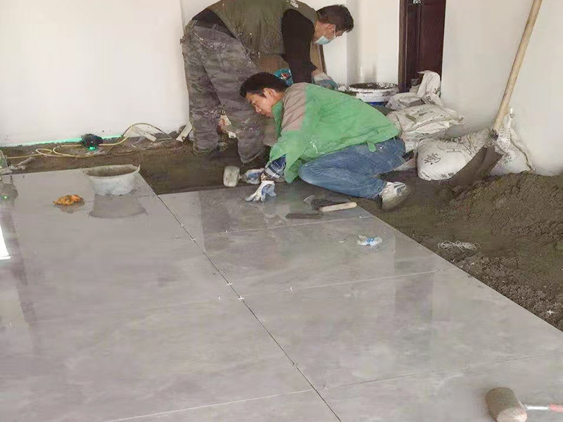 客廳地面貼磚：首先要把基層用水澆濕，除去雜物和浮沙。再抹結(jié)合層，需要注意的是要使用1：3的干性水泥漿，按照水平線探鋪平整，然后再把磚放在沙漿上用膠皮錘振實(shí)。這時(shí)再把地面磚取下澆抹水泥漿，然后把地面磚放實(shí)振平就可以了。采用干鋪法可以有效地避免鋪裝過(guò)程中造成的空鼓、氣泡等現(xiàn)象發(fā)生。但是干鋪法的技術(shù)含量比較高，所以費(fèi)用也會(huì)比較貴。